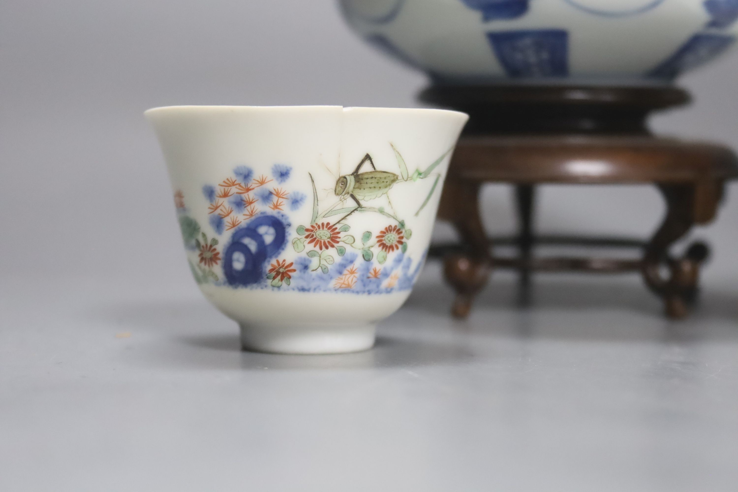 A pair of Chinese blue and white jars and covers, 6.5cm, on wood stands, a Chinese blue and white bowl and two small enamelled wine cups